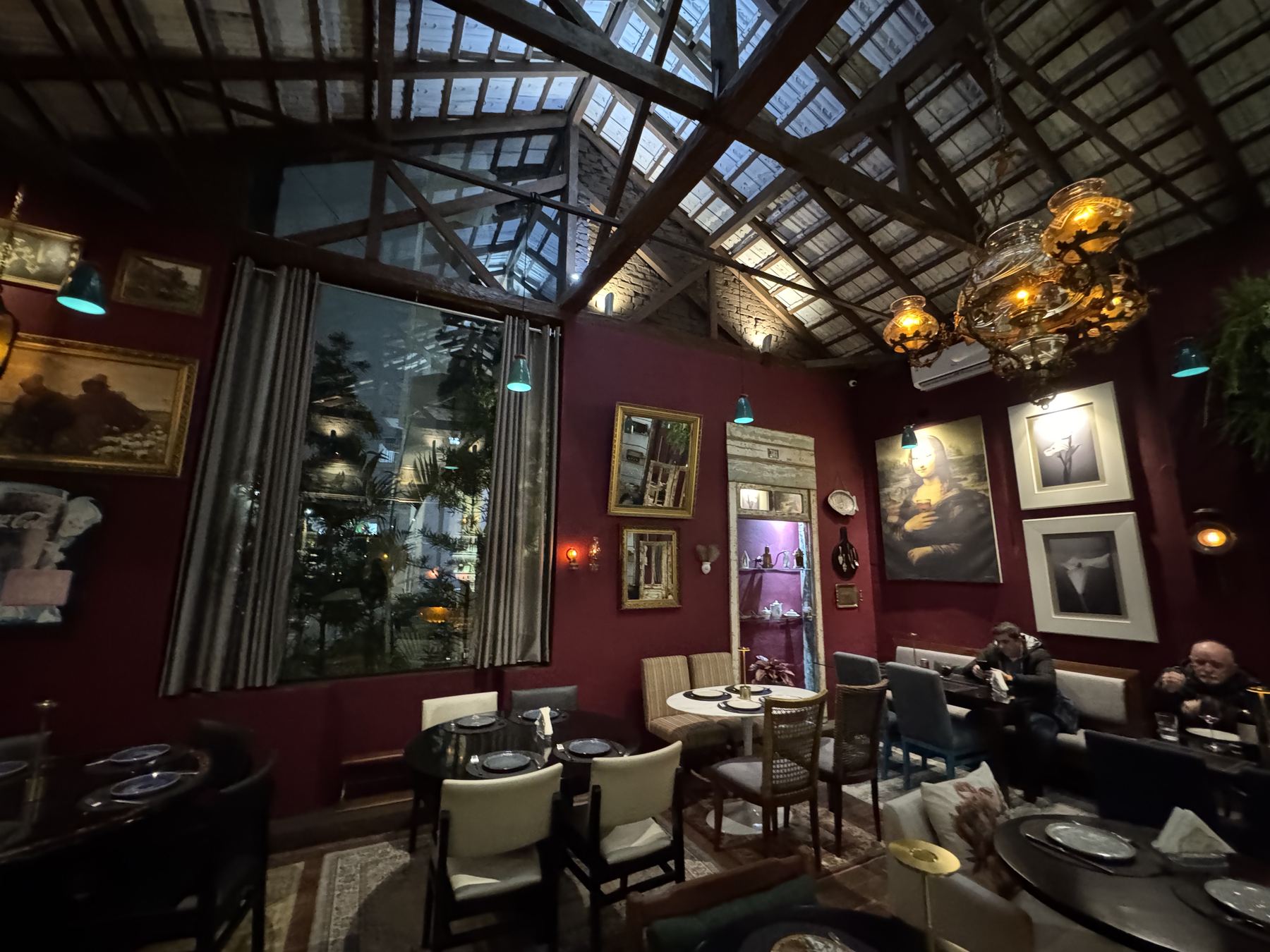Sal&atilde;o da Casa Gourmet com claraboia, quadros e mesas postas